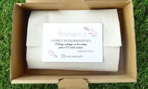 Karta z podziękowaniem w otwartym kartonie na tle trawy.