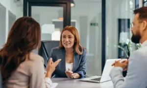 Consulente spiega opzioni per cointestatario mutuo senza reddito, con coppia che ascolta attentamente.
