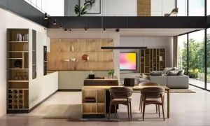 Moderna cocina con ventanal, estanterías de madera y una isla central. El espacio se abre a un salón con sofá y vistas al exterior.