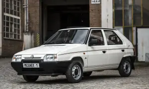 Biały Skoda Favorit z lat 90. na tle ceglanego budynku.