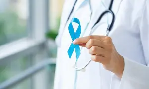 Lekarz trzyma niebieską wstążkę, symbol walki z rakiem prostaty. Badanie rezonansem magnetycznym prostaty jest kluczowe w diagnostyce.