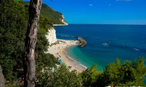 Malownicza plaża nad Adriatykiem, z białymi klifami i turkusową wodą.
