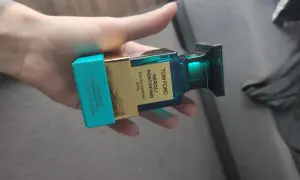 Dłoń trzyma buteleczkę perfum Tom Ford Neroli Portofino.