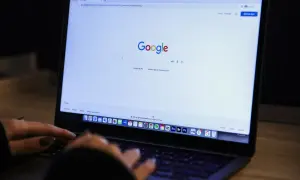 Osoba wpisuje w wyszukiwarkę Google frazę "jak zablokować ai w google", szukając informacji o ograniczeniu sztucznej inteligencji.