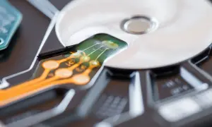 Zbliżenie na elektronikę dysku twardego, pokazujące ścieżki i złącza. Dowiedz się, jak dodać dysk do swojego komputera.