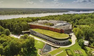 Nowoczesny hotel nad Narwią z zielonym dachem i stawem, otoczony lasem. Idealne miejsce na wypoczynek.