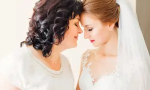 Mama i córka, obie elegancko na ślub córki, dzielą wzruszającą chwilę.