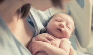 Delikatne objęcie noworodka, który śpi spokojnie, gdy zarasta ciemiączko.
