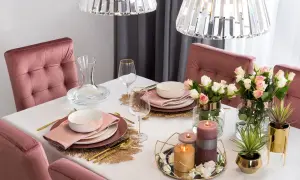 Elegancko nakryty stół z różowymi krzesłami, kwiatami i świecami. Jak ułożyć tiul na stole, by stworzyć taką atmosferę?
