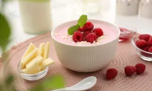 Różowy deser z malinami i miętą, obok ser i mleko. Czy pudding jest zdrowy? Zależy od składników!
