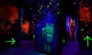 Mroczna arena do laser tag z neonowymi grafikami, strzałkami i postaciami.