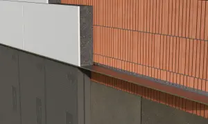 Warstwa styropianu przyklejona do ściany, obok ceglanej okładziny. Pokazano detale montażu.