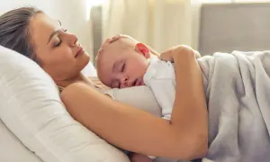 Mama i dziecko śpią wtuleni w siebie. To piękny moment kangurowania, pełen miłości i spokoju.