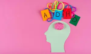 Sagoma di testa con cervello rosa e lettere colorate che formano ADHD, per capire come diagnosticarla.