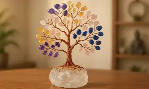 Árbol de la vida con ramas de alambre y hojas de piedras semipreciosas de colores. La base es una gran piedra de cuarzo. Un detalle decorativo para poner piedras alrededor de un árbol.