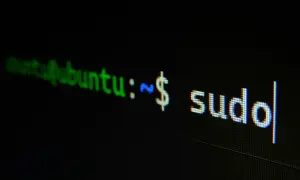 Terminal z napisem "ubuntu:~ $ sudo". Początek historii Linuxa, gdzie polecenie sudo otwiera drzwi do zarządzania systemem.