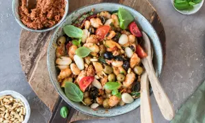 Gnocchi-Salat mit Pesto, Tomaten, Oliven und Pinienkernen in einer Schüssel.