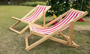 Dwa drewniane leżaki w czerwono-białe pasy, idealne do relaksu. Dowiedz się, jak zrobić leżak drewniany.