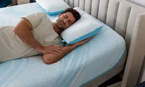 Man sleeping peacefully on a Tempur-Pedic pillow, enjoying the comfort and subtle, fresh tempurpedic pillow smell.