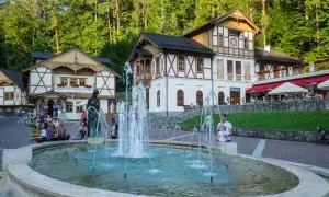 Fontanna i urokliwe budynki tworzą piękne **Szczawnica atrakcje**. Ludzie odpoczywają, ciesząc się atmosferą uzdrowiska.