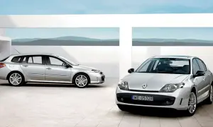 Dwa srebrne Renault Laguna 3 2.0 dCi: kombi i sedan, stojące na nowoczesnym placu z widokiem na góry.