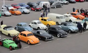En samling 90 tals bilar, mestadels bubblor och några skåpbilar, uppradade på en parkering.