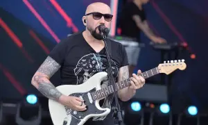 Łysy gitarzysta z tatuażami gra na białej gitarze. W tle klawiszowiec. Koncert, jakby to były kombi piosenki alfabetycznie.