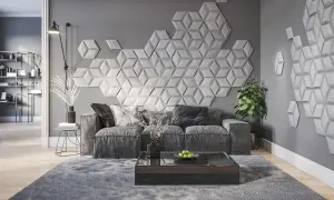 Nowoczesna dekoracja co na ścianę w pokoju: geometryczne panele 3D tworzą efektowny wzór nad szarą sofą.