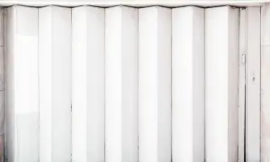 Białe drzwi harmonijkowe złożone, widok z przodu.