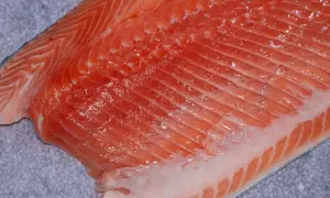Surowy filet z pstrąga łososiowego, bogaty w kwasy omega-3. Czy pstrąg łososiowy jest zdrowy? Tak, to doskonałe źródło białka i witamin.
