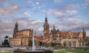 Piękny widok na zamek i kościół w Dreźnie, z fontanną i ludźmi spacerującymi po placu.