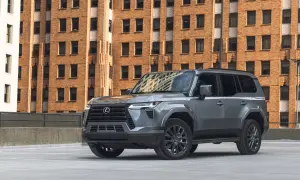 Szary Lexus GX 550 na tle ceglanego budynku.