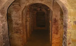 Corridoio sotterraneo con archi in mattoni e pietra a Monsampolo del Tronto, evocando misteri antichi.