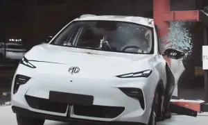 Białe chinskie auto MG po teście zderzeniowym Euro NCAP, z rozbitą szybą i uszkodzonymi elementami.