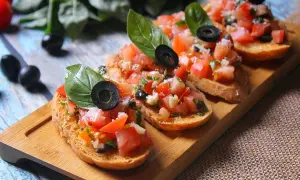 Bruschettas appétissantes avec tomates fraîches, basilic et olives noires sur du pain grillé. Un délice de pain bruschetta.