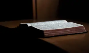 En öppen bibel ligger på ett träbord. Sidorna är fyllda med text, och det ser ut som om det är ett av breven som skrevs Paulus brev till.