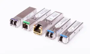 Różne moduły SFP i SFP+ w metalowych obudowach, niektóre z zielonymi lub niebieskimi złączami, inne z pozłacanym portem RJ45.