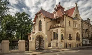 Elegancka willa w stylu secesja Młoda Polska, z bogatymi zdobieniami i kutą bramą.