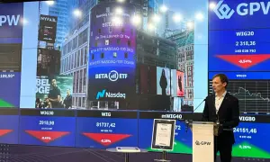 Prezentacja na GPW z informacjami o ETFach, w tym o BETA ETF NASDAQ-100. W tle widać ekrany z danymi giełdowymi.