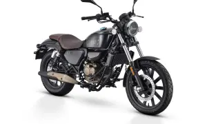 Czarny motocykl w stylu retro, z brązowym siedzeniem i złotymi elementami silnika. To najmocniejsze 125 na b, gotowe na każdą drogę.