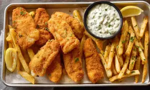 Chrupiące filety rybne i złociste frytki, idealne do domowego fish and chips przepisu. Podane z sosem tatarskim i cytryną.