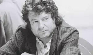 Enrique Morente joven, con su melena rizada y mirada pensativa, viste chaqueta de rayas.