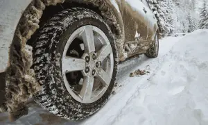Samochód na śniegu, z błotem i lodem na kołach. Różne rodzaje napędów radzą sobie inaczej w takich warunkach.