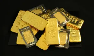 Stos sztabek złota o wysokiej próbie, w tym 1-kilogramowe sztabki i mniejsze opakowane, błyszczące jak skarb. Każda sztabka, oznaczona numerem seryjnym i wagą, świadczy o wartości i czystości tego cennego metalu, symbolizując bogactwo i stabilność.
