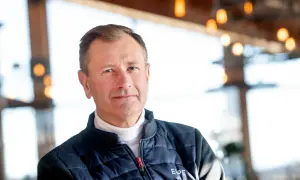 SkiStar VD, Stefan Söderberg, bär en blå dunjacka över en vit polotröja. Bakgrunden är suddig med ljus och trädetaljer.