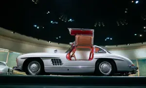 Srebrny Mercedes Gullwing z czerwonym wnętrzem, z otwartymi drzwiami, prezentuje swoje ikoniczne linie.