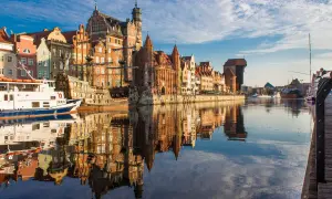 Gdańska starówka z żaglowcem i statkiem wycieczkowym, idealne instagramowe miejsca Gdańsk. Odbicia budynków w wodzie tworzą magiczny widok.
