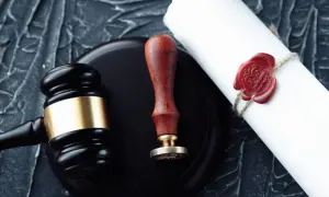 Młotek sędziowski, pieczęć i testament notarialny. Co dalej? Dokumenty prawne i symbole sprawiedliwości.