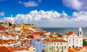 Färgglada hus i Lissabon under en blå himmel med moln. Perfekt lissabon temperatur för att utforska staden.