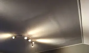 Taket är gipsat och skarvarna är spacklade. En taklampa med flera spotlights lyser upp rummet.